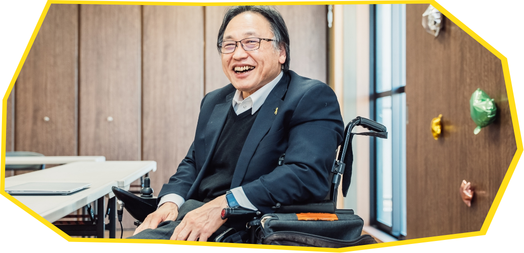 障害者運動に参加している佐藤さんが車椅子に乗って笑顔の様子